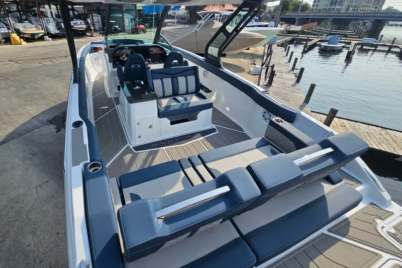 Slide: The Image of 2026 Monterey Elite 30 OB boat with luxurious seating at a marina dock. - 13