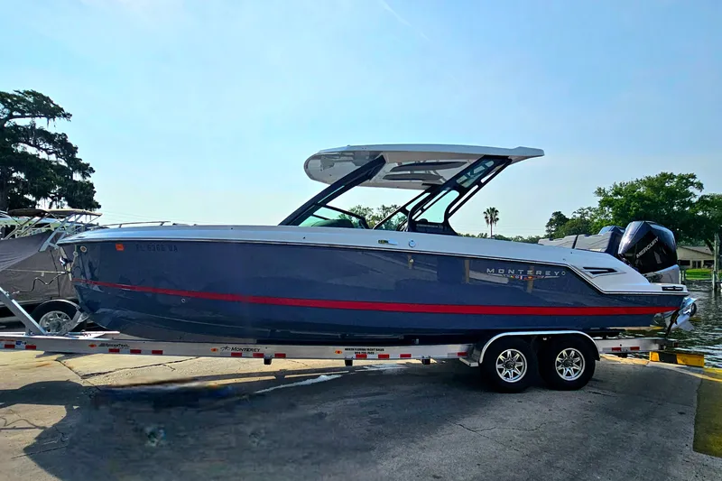 Slide: The Image of 2026 Monterey Elite 30 OB boat on trailer, sleek design, blue and red accents. - 4