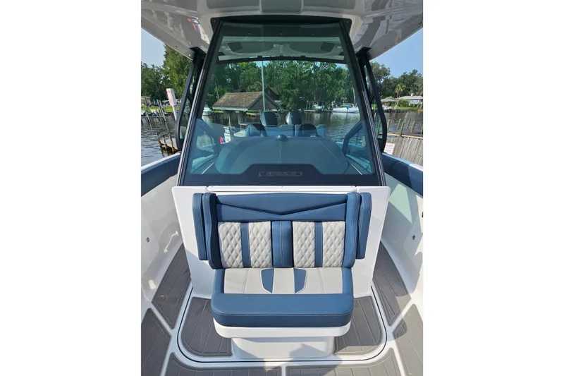 Slide: The Image of 2026 Monterey Elite 30 OB boat interior with blue and gray seating, dockside view. - 28