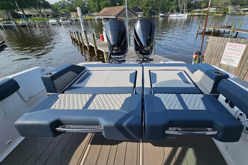 Slide: The Image of 2026 Monterey Elite 30 OB boat with luxurious seating and dual outboard motors at a dock. - 17