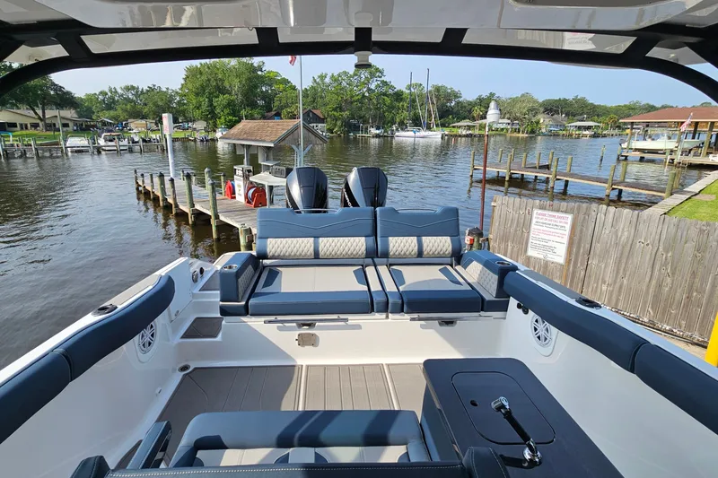 Slide: The Image of 2026 Monterey Elite 30 OB boat interior with luxurious seating at a scenic dock. - 14