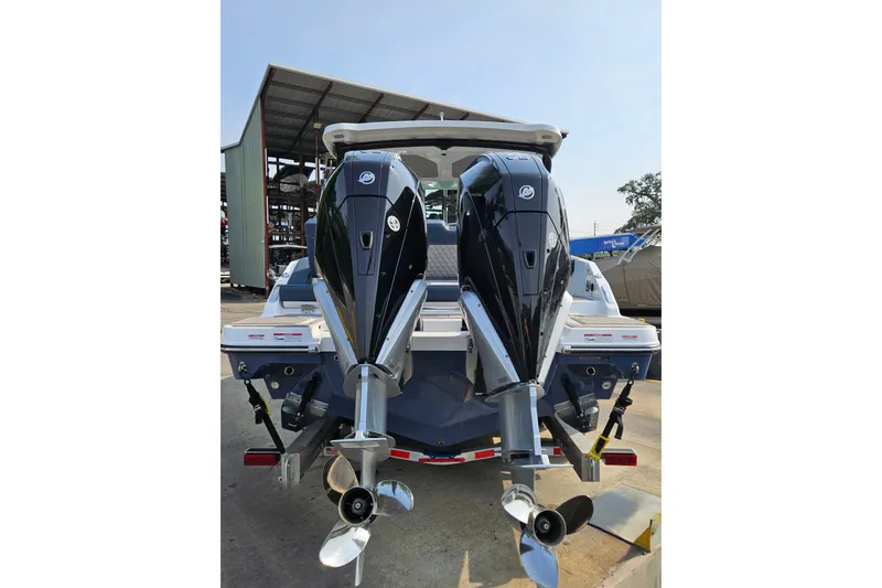Slide: The Image of 2026 Monterey Elite 30 OB boat with dual outboard engines, docked outdoors. - 10