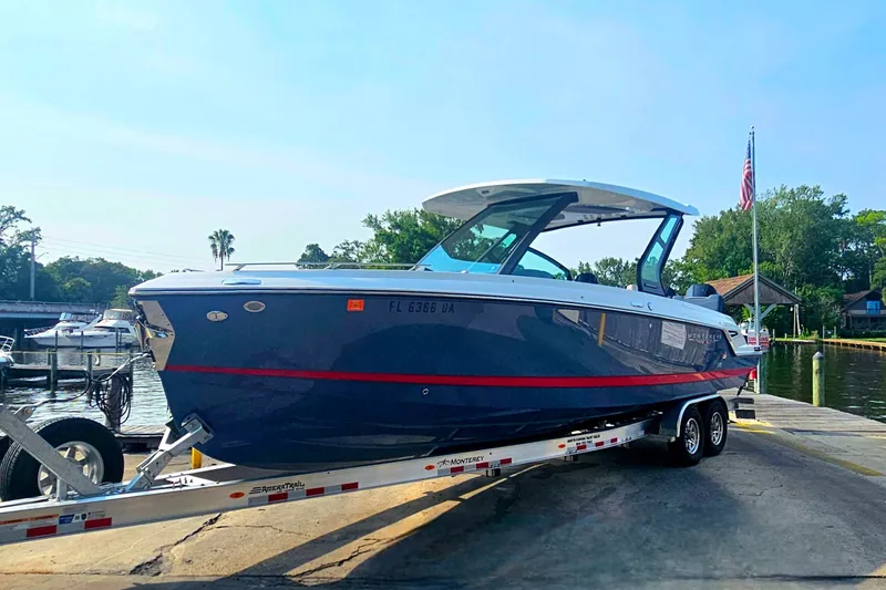 Slide: The Image of 2026 Monterey Elite 30 OB boat on trailer at marina, sunny day. - 3