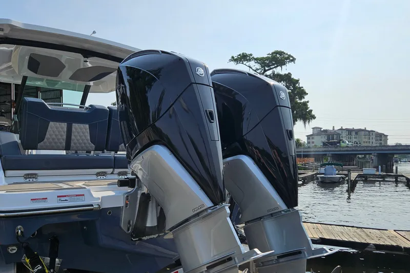 Slide: The Image of 2026 Monterey Elite 30 OB boat with dual outboard engines docked by the waterfront. - 9