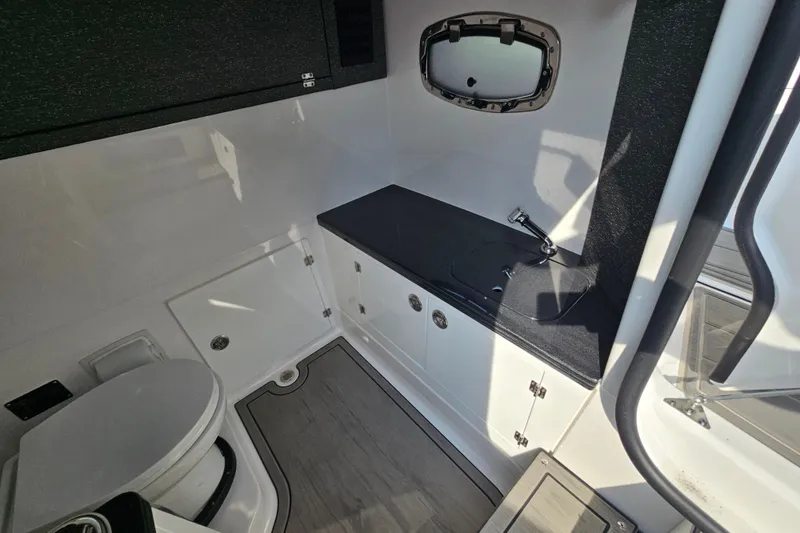 Slide: The Image of Interior of 2026 Monterey Elite 30 OB boat bathroom with sink and toilet. - 30