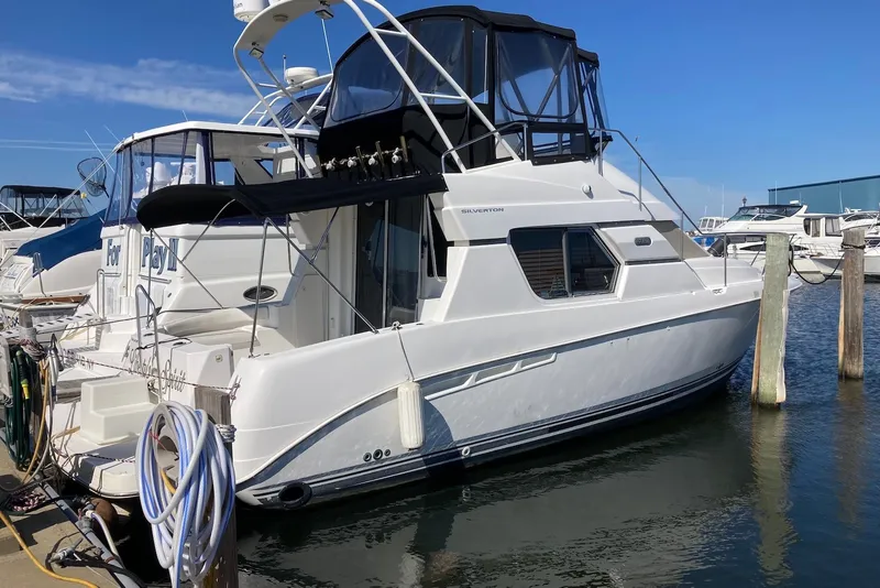 Slide: The Image of 1999 Silverton 351 Sedan yacht docked at marina under clear blue sky. - 3