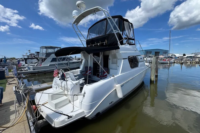 Slide: The Image of 1999 Silverton 351 Sedan yacht docked at marina under blue sky. - 2