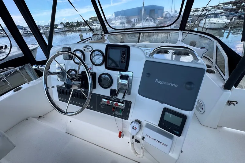 Slide: The Image of 1999 Silverton 351 Sedan helm with steering wheel, gauges, and Raymarine navigation system. - 8