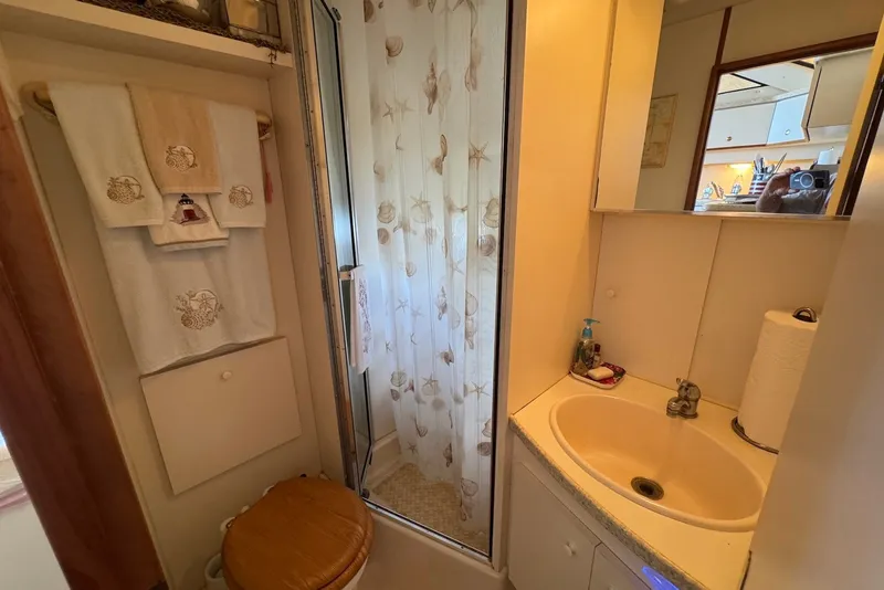 Slide: The Image of Bathroom in 1999 Silverton 351 Sedan with shower, sink, and decorative towels. - 16