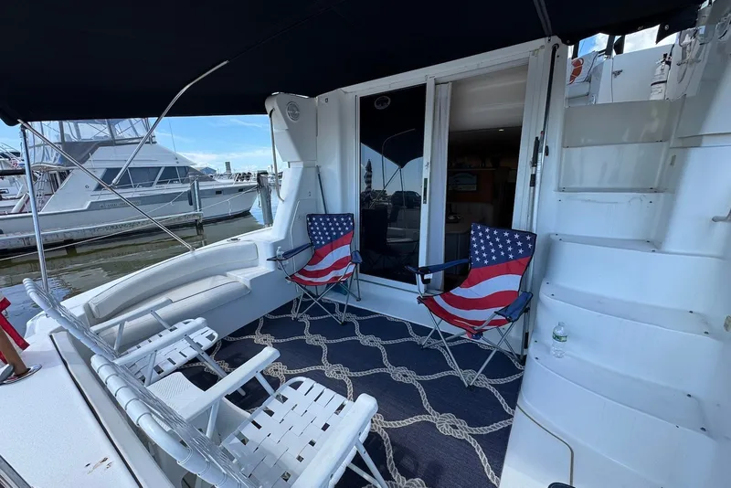 Slide: The Image of 1999 Silverton 351 Sedan yacht deck with American flag chairs and nautical decor. - 4