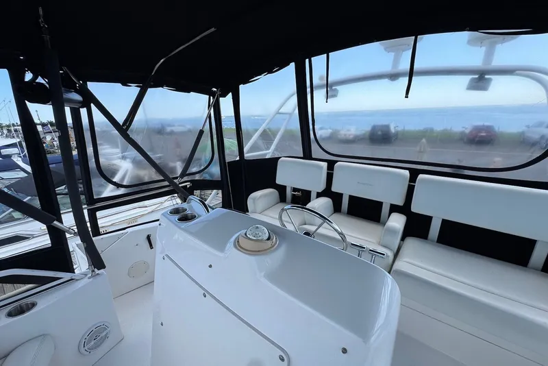 Slide: The Image of Interior view of a 1999 Silverton 351 Sedan yacht with white seating and helm. - 10