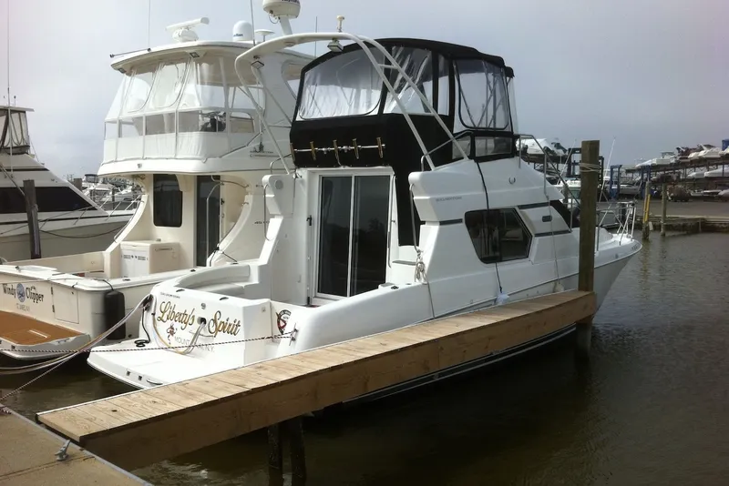 Slide: The Image of 1999 Silverton 351 Sedan yacht docked at marina, featuring sleek design and spacious cabin. - 2