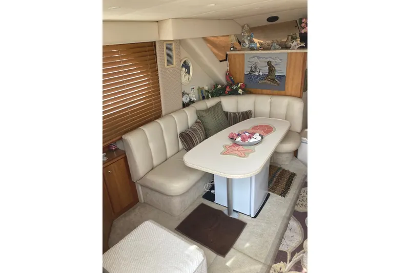 Slide: The Image of Interior of 1999 Silverton 351 Sedan with cozy dining area and nautical decor. - 5