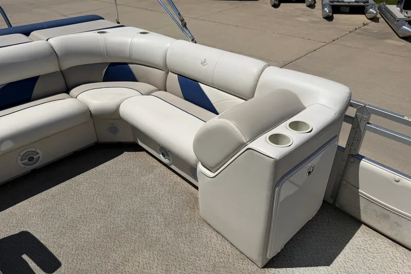 Slide: The Image of 2005 JC 21 NEPTOON TT boat interior with white and blue seating, cup holders, and speakers. - 7