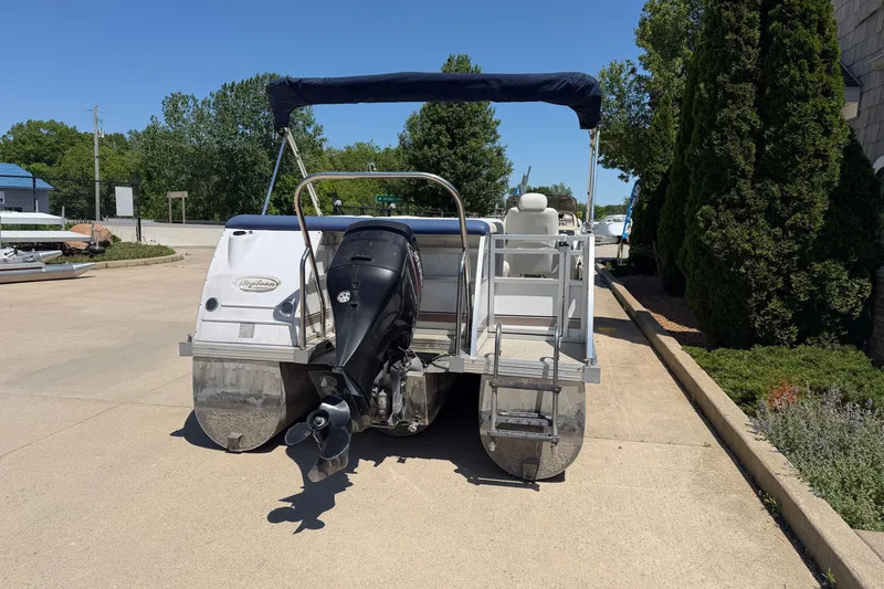 Slide: The Image of 2005 JC 21 NEPTOON TT pontoon boat with outboard motor, parked on concrete. - 3