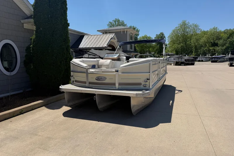 Slide: The Image of 2005 JC 21 NEPTOON TT pontoon boat parked on a sunny driveway. - 2