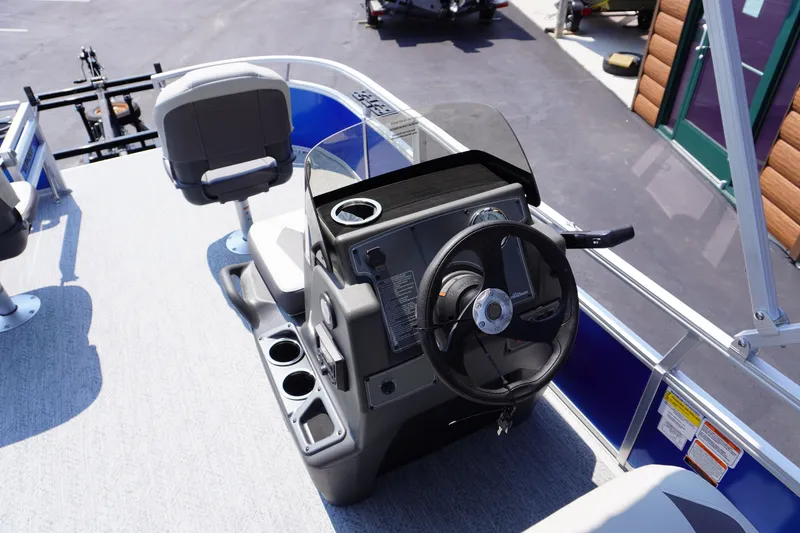 Slide: The Image of 2027 Sun Tracker Bass Buggy 16 DLX pontoon boat helm with steering wheel and seating. - 9