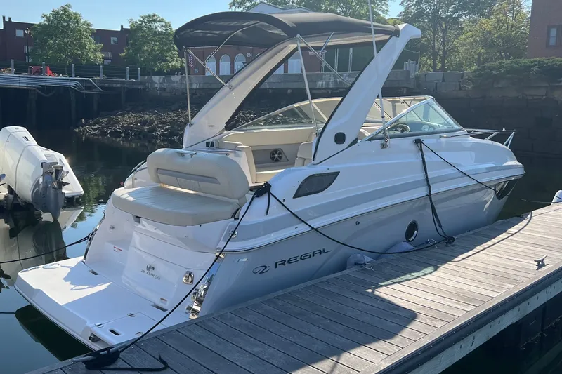 Slide: The Image of 2019 Regal 28 Express boat docked at a marina under sunny skies. - 1