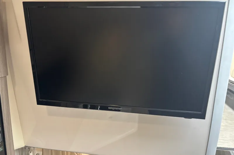 Slide: The Image of Flat-screen TV inside 2019 Regal 28 Express boat cabin. - 35