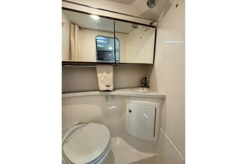 Slide: The Image of 2019 Regal 28 Express boat bathroom with mirror, sink, and toilet. - 11
