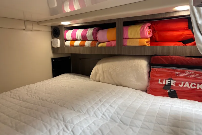 Slide: The Image of Cozy cabin interior of 2019 Regal 28 Express with neatly stored towels and life jackets. - 38