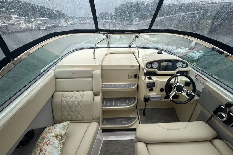 Slide: The Image of Interior of a 2019 Regal 28 Express boat with beige seating and modern dashboard. - 25