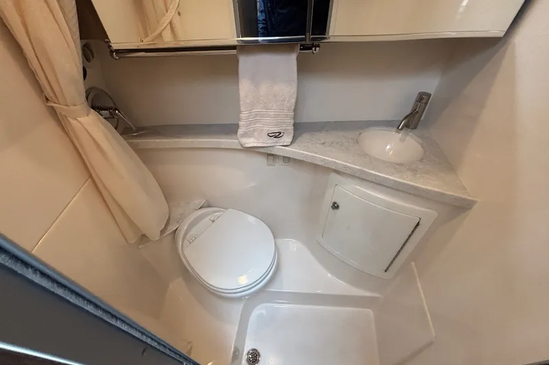 Slide: The Image of Compact bathroom in a 2019 Regal 28 Express boat, featuring a toilet, sink, and shower. - 39