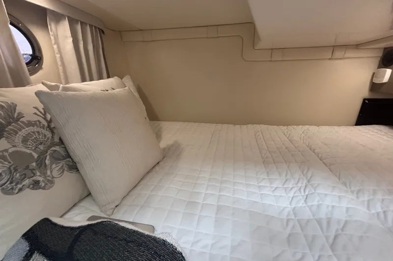 Slide: The Image of Cozy cabin interior of 2019 Regal 28 Express boat with plush bedding and pillows. - 46