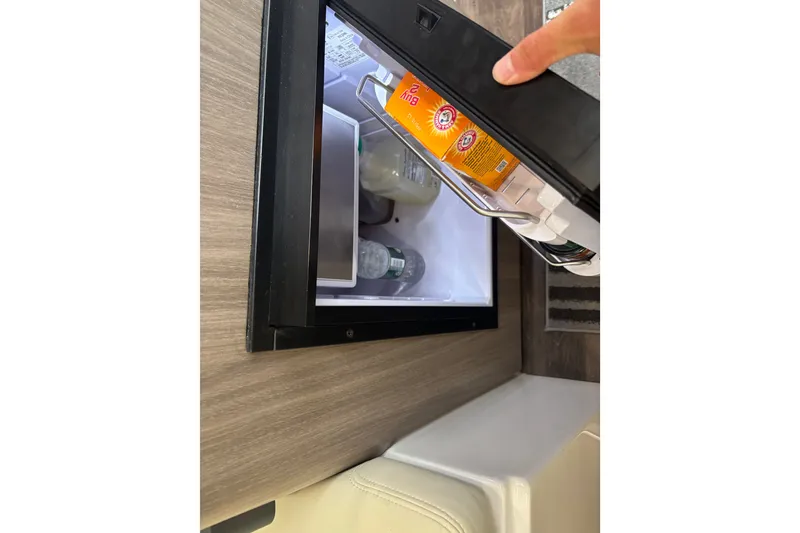 Slide: The Image of Small refrigerator inside 2019 Regal 28 Express boat, stocked with beverages and essentials. - 36