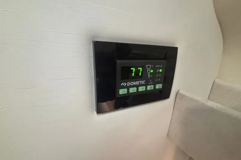 Slide: The Image of Dometic thermostat on 2019 Regal 28 Express boat, displaying temperature at 77 degrees. - 43