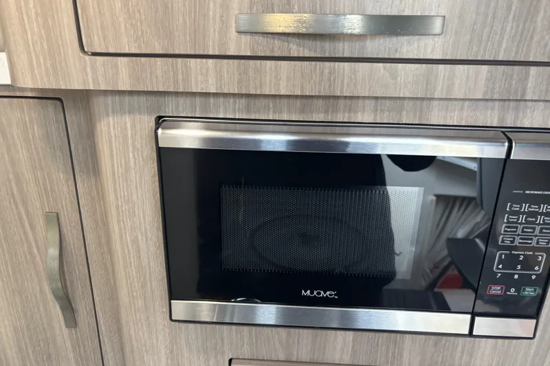 Slide: The Image of Built-in microwave in 2019 Regal 28 Express boat kitchen area. - 33