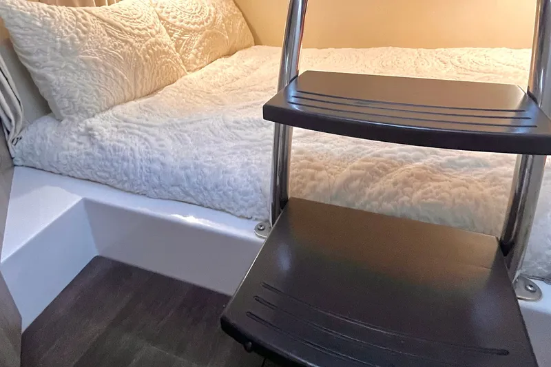 Slide: The Image of Cozy cabin interior of 2019 Regal 28 Express with ladder and plush bedding. - 6