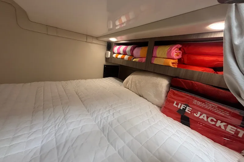 Slide: The Image of Cozy cabin interior of 2019 Regal 28 Express with bedding, towels, and life jackets. - 44