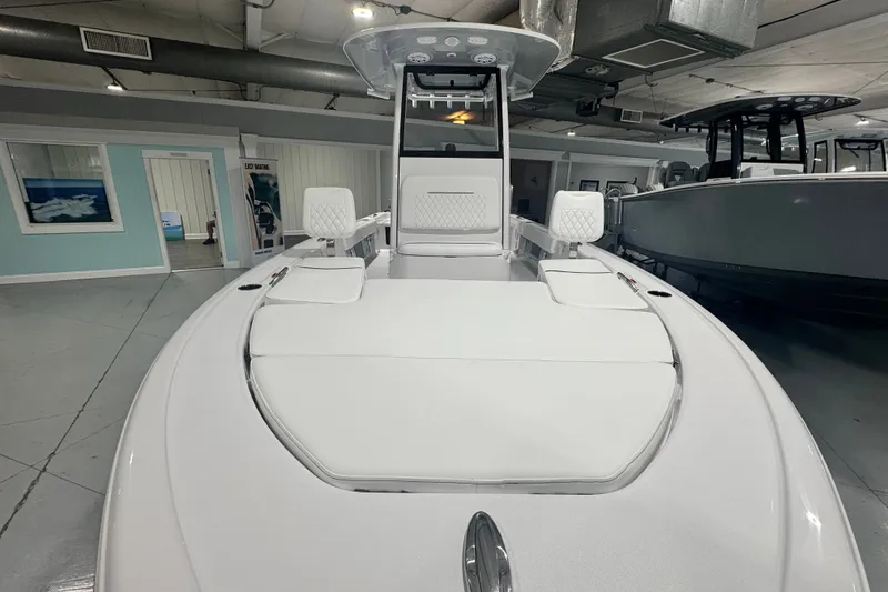 Slide: The Image of 2027 Sportsman Masters 227 Bay Boat interior with white seating in showroom. - 1