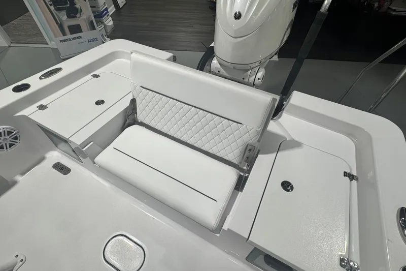 Slide: The Image of 2027 Sportsman Masters 227 Bay Boat with white cushioned seating and storage compartments. - 7