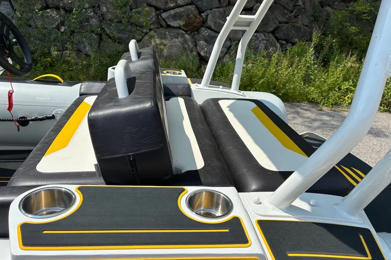 Slide: The Image of 2026 Highfield Velox 420 boat interior with black and yellow seating, cup holders, and steering wheel. - 11