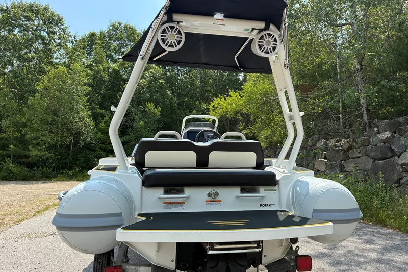 Slide: The Image of 2026 Highfield Velox 420 boat with canopy, parked outdoors, surrounded by lush greenery. - 3