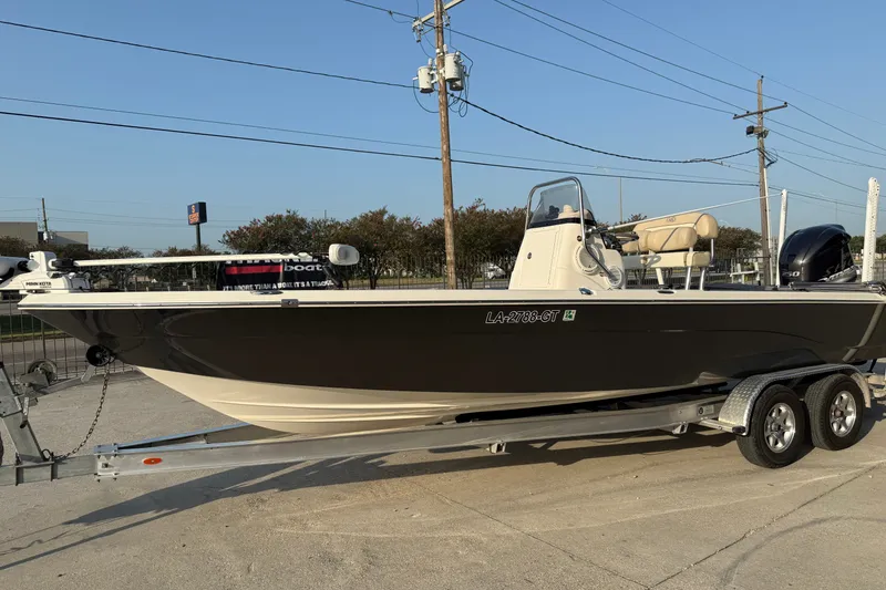 Slide: The Image of 2018 NauticStar 244 XTS boat on trailer, parked outdoors under clear sky. - 6