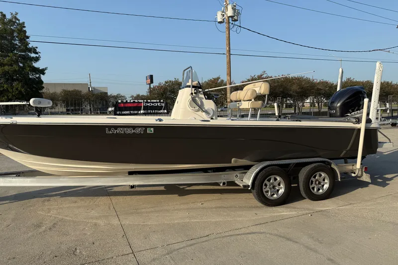 Slide: The Image of 2018 NauticStar 244 XTS boat on trailer, parked outdoors, featuring sleek design and powerful engine. - 7