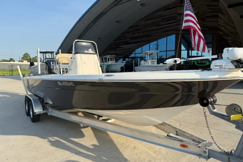 Slide: The Image of 2018 NauticStar 244 XTS boat on trailer with American flag, parked outside a building. - 4