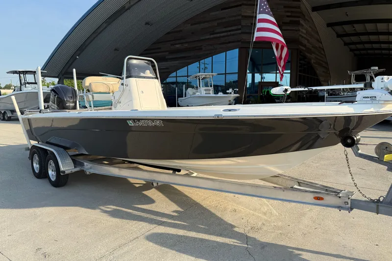 Slide: The Image of 2018 NauticStar 244 XTS boat on trailer, parked outside a modern building. - 3