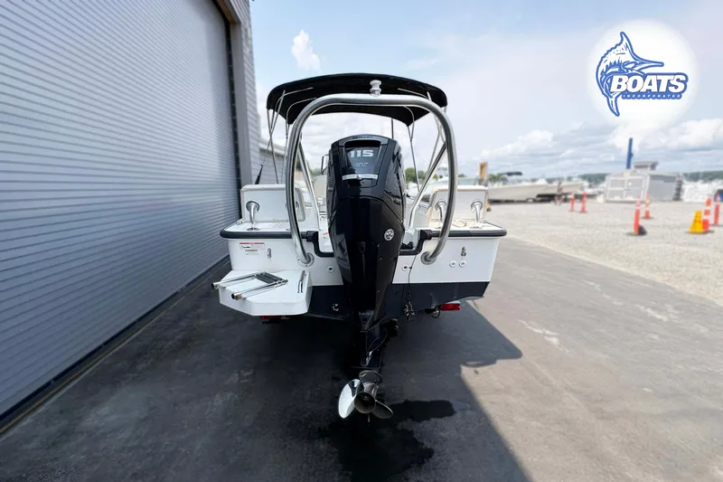 Slide: The Image of 2018 Boston Whaler 170 Montauk boat with outboard motor, parked near a warehouse. - 12