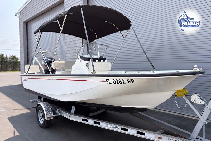 Slide: The Image of 2018 Boston Whaler 170 Montauk boat on trailer, parked outside a building. - 1