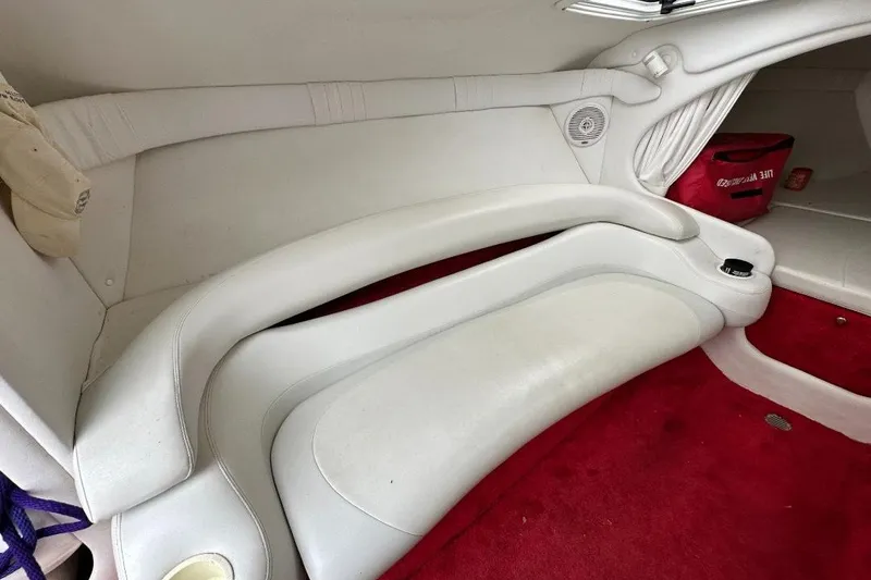 Slide: The Image of Interior of a 1999 Baja 29 Outlaw boat with white seating and red carpet. - 17
