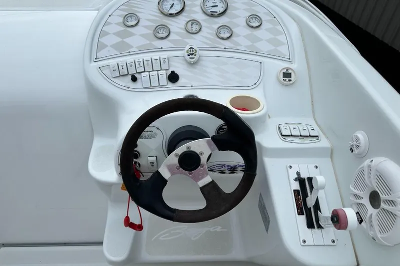 Slide: The Image of 1999 Baja 29 Outlaw boat dashboard with steering wheel and control panel. - 9