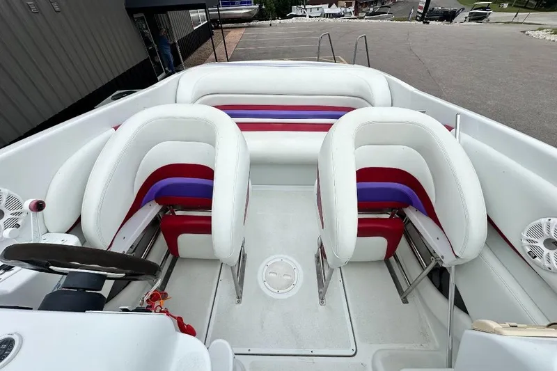 Slide: The Image of 1999 Baja 29 Outlaw boat interior with white, red, and purple seating. - 6