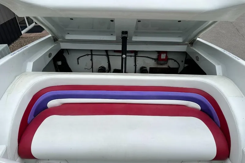 Slide: The Image of 1999 Baja 29 Outlaw boat interior with colorful seating and open engine compartment. - 12