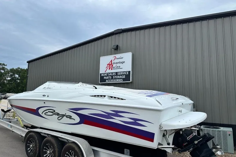 Slide: The Image of 1999 Baja 29 Outlaw boat on trailer at marine dealership. - 1
