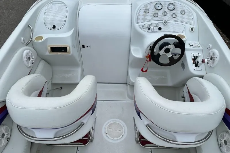 Slide: The Image of 1999 Baja 29 Outlaw boat cockpit with white seats and dashboard controls. - 5