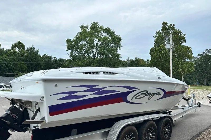 Slide: The Image of 1999 Baja 29 Outlaw speedboat on trailer, featuring sleek design and vibrant graphics. - 3